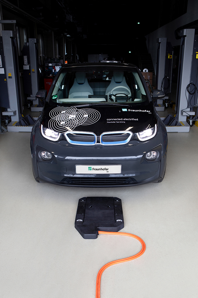 Elektroauto mit überfahrbarem Ladesystem in Garage