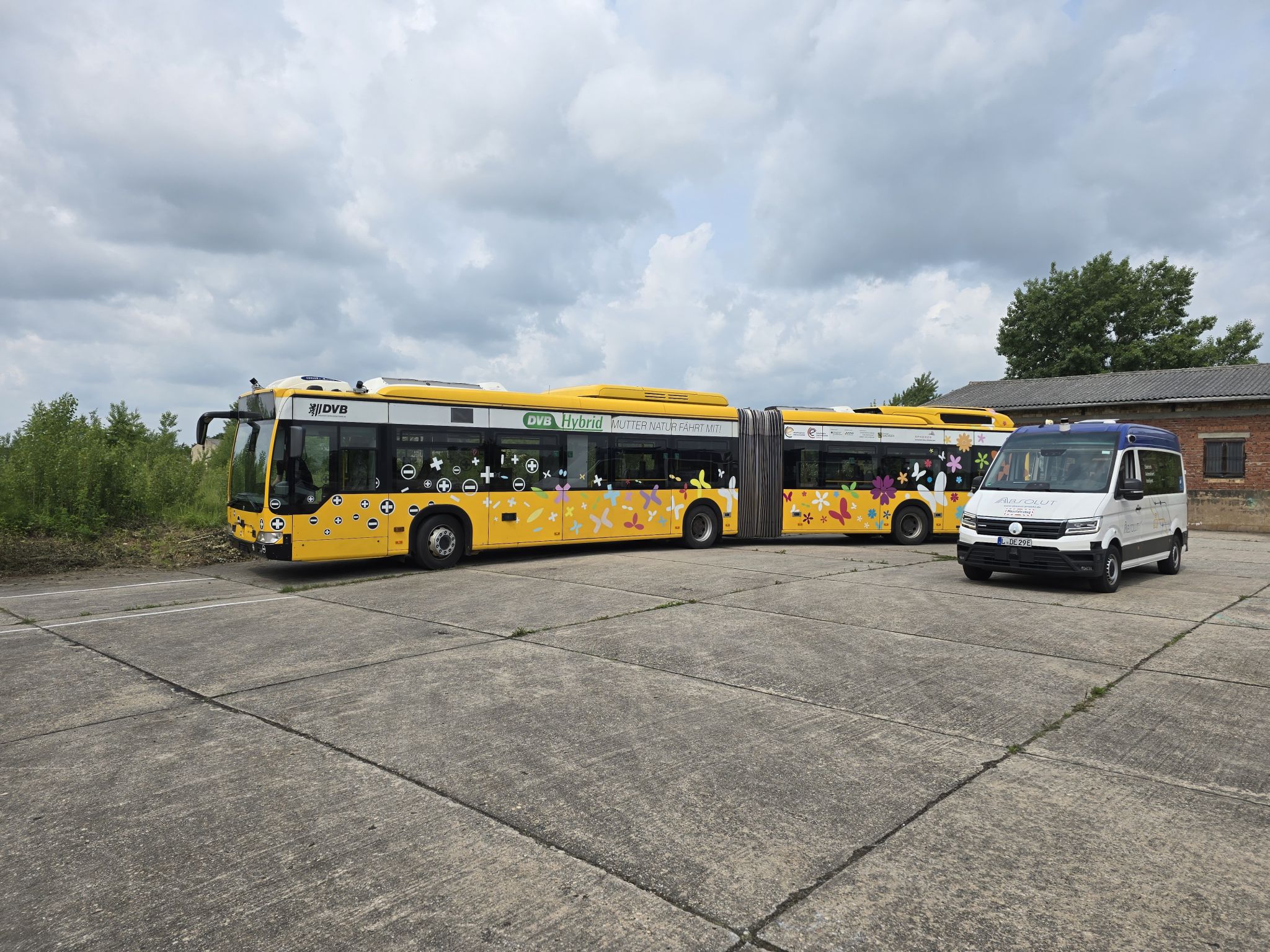 An articulated bus and a transporter van at the demo site in Torgau